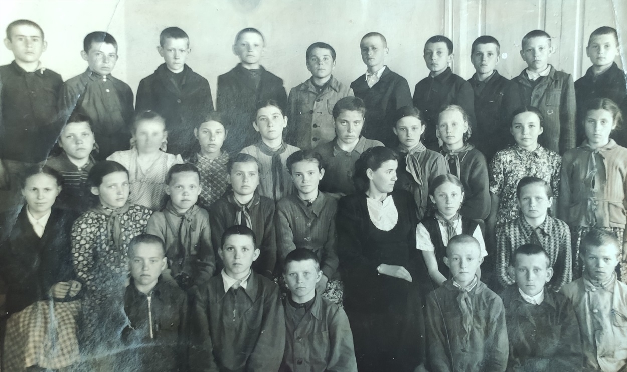 Третий класс Дмитриевской начальной школы. На переднем плане классный руководитель Александра Руднева. 1951 год