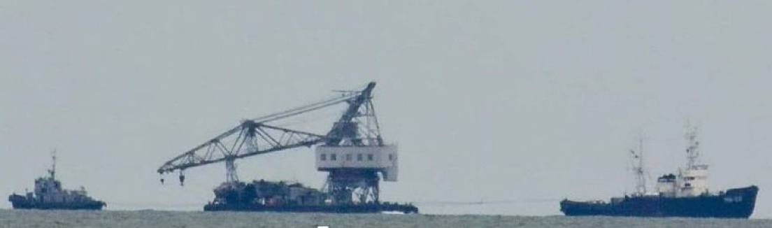 Невідомий плавучий кран і буксири на виході з порту Маріуполя