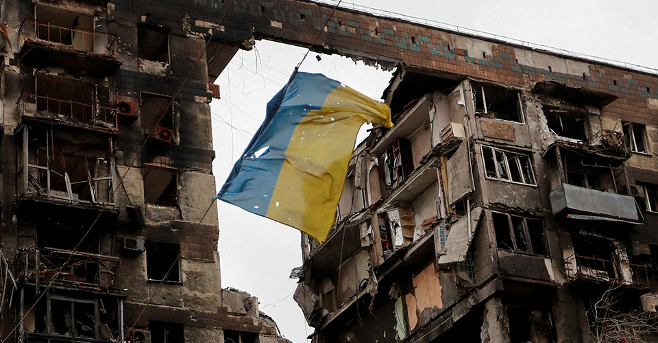 Прапор України на фоні зруйнованого будинку в Маріуполі