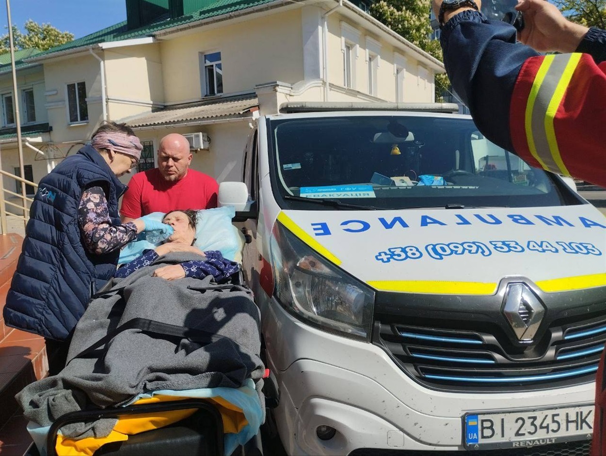 Волонтери транспортують маломобільну людину до волонтерського центру