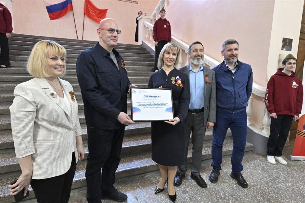 На фото: призначена росіянами ректор університету Катерина Степанюк отримує від заступника голови уряду рф Дмитра Чернишенка сертифікат на мікроавтобус, який напевно також було знищено внаслідок бойових дій.